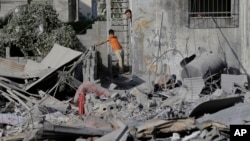 Warga Palestina memeriksa kerusakan akibat serangan udara Israel, di beberapa gedung di Gaza, Jalur Gaza utara, Sabtu, 2 Agustus 2014. 