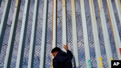 រូបឯកសារ៖ បុរស​ម្នាក់​ទប់​ខ្លួន​ទៅ​នឹង​បង្គោល​របង​នៅ​តាម​ឆ្នេរ​សមុទ្រ​ក្នុង​ទីក្រុង Tijuana ប្រទេស​ម៉ិកស៊ិក។