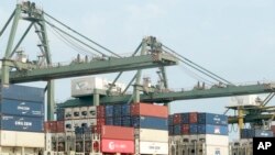 FILE - In this May 3, 2020, photo, containers are loaded on a ship at the Saigon port in Ho Chi Minh City, Vietnam.