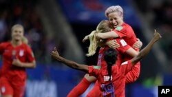 United States' scorer Samantha Mewis lifts her teammate Megan Rapinoe as she celebrates her side's 4rth goal during the Women's World Cup soccer match between United States and Thailand June 11, 2019. (AP Photo/Alessandra Tarantino)