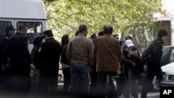 Chinese youths detained by police officers from an area where members of a unregistered church planned to hold Easter service are led into a police station in Beijing Sunday, April 24, 2011.