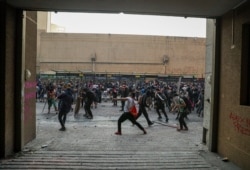 Anti-government protesters clash with police, seen from the entrance to a building's parking lot in Santiago, Chile, Oct. 29, 2019.