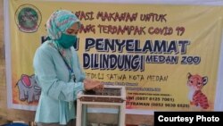 Seorang warga saat memberikan donasi koin peduli satwa-satwa di Kebun Binatang Medan. (Courtesy: Medan Zoo)