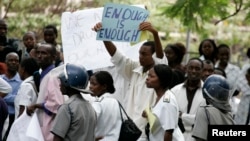 FILE - Zimbabwean riot police officers stand in front of doctors and nurses demonstrating over the deteriorating health system, outside Parirenyatwa public hospitals in Harare, Nov. 18, 2008.