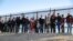 FILE - A group of Central American migrants surrenders to U.S. Border Patrol Agents south of the U.S.-Mexico border fence in El Paso, Texas, March 6, 2019.