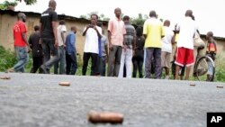 A man looks across at spent bullet casings lying on a street in the Nyakabiga neighborhood of Bujumbura, Burundi, Saturday, Dec. 12, 2015. Burundi's political violence continued Saturday as a number of people were found shot dead.