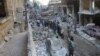 People inspect the damage at a site after it was hit by shelling carried out by rebels at Syrian government-held areas of Aleppo, Syria, in this handout picture provided by SANA, July 11, 2016.