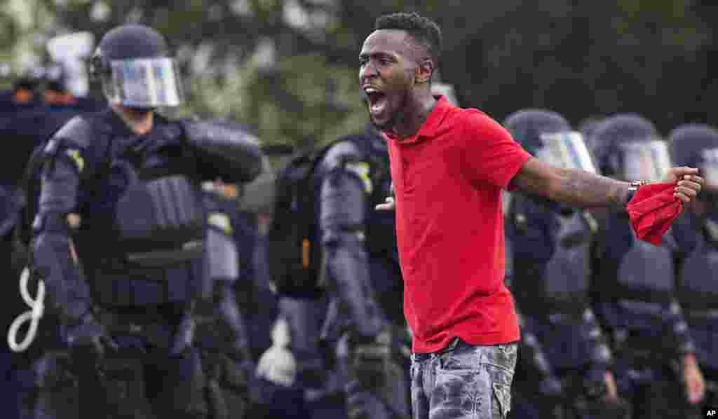 A protester yells at police in front of the Baton Rouge Police Department headquarters after police arrived in riot gear to clear protesters from the street in Baton Rouge, Louisiana, July 9, 2016.
