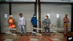 Residents of Yeoville neighborhood of Johannesburg, South Africa, wait in line to enter a grocery store, April 3, 2020. 