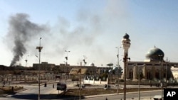 A plum of smoke is seen following a wave of attacks prior to the storming a police compound in the western Iraqi city of Ramadi, January 15, 2012.