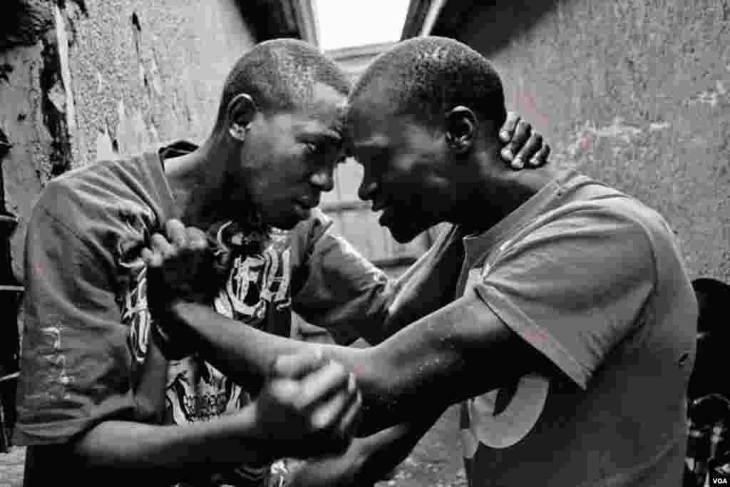 Vansing (left), age 20, fights with his friend Belusi, age 19, because he caught Belusi stealing from him, Giporoso, Kigali, Rwanda. Fri, Nov. 15, 2013. (Hamada Elrasam for VOA)