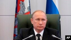 FILE - Russian President Vladimir Putin heads a meeting with senior military officials at the Defense Ministry's control room in Moscow, Dec. 19, 2014. 