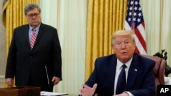 FILE - President Donald Trump and Attorney General William Barr are pictured in the Oval Office at the White House, May 28, 2020, in Washington.