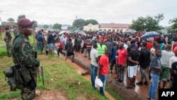 Malawi Defence Force members watch participants in Lilongwe, Jan. 16, 2020, during a protest against alleged attempts to bribe judges overseeing a legal challenge to the re-election last year of the country's president.