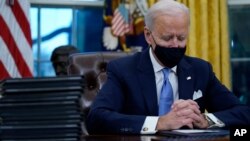 លោក​ប្រធានាធិបតី Joe Biden ផ្អាកបន្តិច នៅ​ពេល​លោក​ចុះ​ហត្ថលេខា​លើ​​​បទបញ្ជា​ប្រធានាធិបតីដំបូង​ៗ​របស់​លោក​នៅក្នុង​ការិយាល័យ​ប្រធានាធិបតី​ក្នុង​សេតវិមាន កាលពី​ថ្ងៃពុធ ទី២០ ខែមករា ឆ្នាំ២០២១ នៅ​រដ្ឋធានី​វ៉ាស៊ីនតោន។