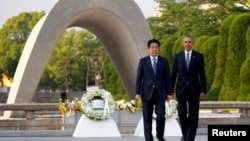 U.S. President Barack Obama (R) and Japanese Prime Minister Shinzo Abe walk in front of a cenotaph after they laid wreaths at Hiroshima Peace Memorial Park in Hiroshima, Japan, May 27, 2016.