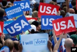 Supporters of Democratic presidential candidate Hillary Clinton hold up signs at a rally, Nov. 5, 2016, in Pembroke Pines, Fla