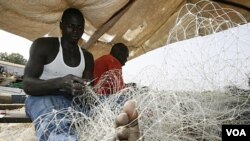 Nelayan Guinea-Bissau sedang meyiapkan jala untuk menangkap ikan. Mereka kalah bersaing dengan nelayan-nelayan Uni Eropa yang mempunyai peralatan lebih moderen.