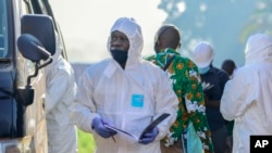 Forensics officers search near the scene of an explosion in the Komamboga suburb of the capital Kampala, Uganda, Oct. 24, 2021. 