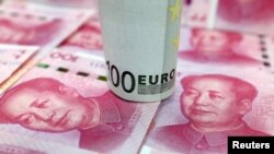 A 100-Euro banknote and Chinese 100-yuan banknotes are seen in this picture illustration, in Beijing, China, Jan. 21, 2016.