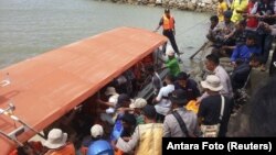 Rescue workers, police and residents prepare to unload the body of a ferry victim in Kolaka, South East Sulawesi, Indonesia, Dec. 20, 2015.