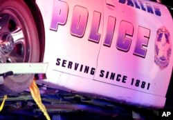 A Dallas police vehicle with a red stain beneath the door is hauled away from the Baylor University Medical Center on July 8, 2016, in Dallas. (AP