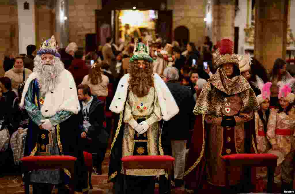 Juan Miguel Aguilar, Diego Sanchez and Angel Ballesteros dressed up as Melchior, Gaspar and Balthazar, the Three Wise Men, worship a statue of Christ inside a church, as they tour the city center visiting churches, ahead of the Epiphany parade, in Ronda, Spain, Jan. 4, 2025.&nbsp;