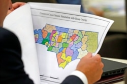 FILE - A lawmaker studies a district map during a joint select committee meeting on redistricting in Raleigh, N.C., July 26, 2017.