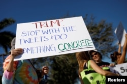 People holding placards take part in a protest in support of gun control in Coral Springs, Fla., Feb. 17, 2018.