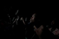 FILE - Haitians watch a television broadcast of the match between Haiti and Canada, in a park of Petion Ville, Port-au-Prince, Haiti, June 29, 2019.
