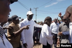 The leader of Liberia's ruling party Coalition for Democratic Change, President George Weah, walks with his wife, Clar Weah, after casting his vote during the presidential elections in Monrovia, Liberia, on Oct. 10, 2023.