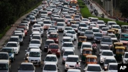 FILE - Traffic moves at dusk in New Delhi, India, Sept. 23, 2014. New Delhi is beginning an experiment to reduce the number of private cars on roads in hopes of curbing air pollution levels.
