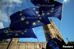 Seorang demonstran mengibarkan bendera Uni Eropa di luar Gedung Parlemen di London, Inggris, 13 September 2017. (Foto: REUTERS/Hannah McKay)