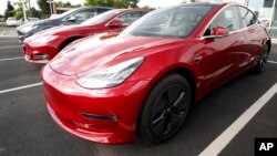 FILE - 2018 Model 3 sedans sit on display outside a Tesla showroom in Littleton, Colo., US.