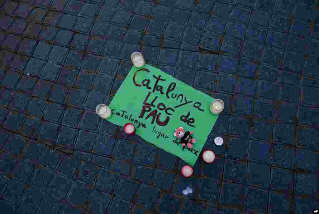 A paper that reads &quot;Catalunya &mdash; place of peace&quot; is placed along with candles on the pavement in Las Ramblas, Barcelona, Spain, Aug. 18, 2017. Spanish police said the manhunt intensified for the perpetrators of Europe&#39;s latest rampage claimed by the Islamic State.
