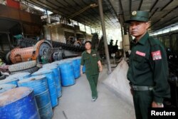 FILE - United Wa State Army (UWSA) soldiers are seen in a tin mine factory at Man Maw in ethnic Wa territory in northeast Myanmar, Oct. 5, 2016.