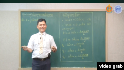 គ្រូបង្រៀនម្នាក់ កំពុងបង្រៀនមុខវិទ្យាគណិតវិទ្យា សម្រាប់សិស្សថ្នាក់ទី១២ តាមវីដេអូដែលត្រូវបានផ្សាយលើបណ្តាញសង្គមហ្វេសប៊ុករបស់ក្រសួងអប់រំ យុវជននិងកីឡា។ (រូបថតដកស្រង់ពីវីដេអូ)