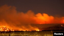 FILE - Smoke and flame rise from Park Fire burning near Chico, California, July 25, 2024. Picture taken with long exposure. 