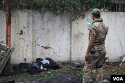 An Iraqi soldier takes pictures of a dead body in Mosul, March 2, 2017, that soldiers say belonged to an IS militant charged with sending armed drones to kill Iraqi forces in eastern Mosul. (H. Murdock/VOA)