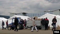 A tractor is seen transporting supplies through the make-shift reception center for migrants and asylum-seekers in Traiskirchen, Austria. (Photo - VOA video grab)