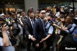 Andy Chan, a founder of the Hong Kong National Party, is surrounded by photographers as he leaves the Foreign Correspondents' Club in Hong Kong, Aug. 14, 2018.