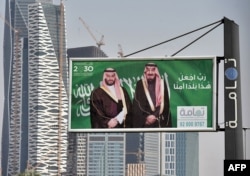 A picture taken on October 22, 2018 shows portraits of Saudi King Salman (R) and his son Crown Prince Mohammed bin Salman (MBS) in Riyadh one day before the Future Investment Initiative FII conference.