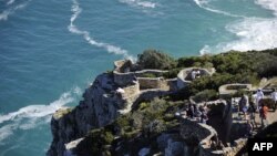 FILE - Tourists enjoy the view from Cape Point on the southern tip of the Cape Peninsula, about 50 kilometers south of Cape Town, South Africa, May 2010.