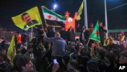 Residents celebrate following the signing of a breakthrough deal between Syria's interim government and the SDF, the Kurdish-led authority that controls the country's northeast, in Qamishli, northeastern Syria, March 10, 2025.