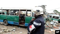 Un policier traverse une cour jonchée de carcasses de véhicules et de débris, après l'explosion du 4 mars