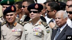 FILE - Egyptian Defense Minister Gen. Abdel-Fattah el-Sissi, center, Egyptian Prime Minister Hazem el-Beblawi, right, at funeral of Giza Police General Nabil Farrag, Cairo, Egypt.