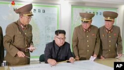 Shugaban Korea ta Arewa Kim Jong Un (a zaune) tare da wasu hafsoshin sojin kasar