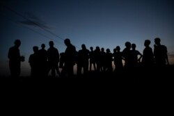 FILE - Refugees who fled the conflict in the Ethiopia's Tigray gather after the sun sets in Hamdayet, eastern Sudan, near the border with Ethiopia, March 23, 2021.