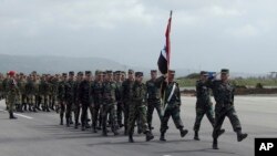 នេះ​ជារូបភាពដែល​ផ្តល់​ដោយ​ក្រសួង​ការពារជាតិ​រុស្ស៊ី បង្ហាញ​ពី កងទាហាន​ស៊ីរីហែ​ក្បួន​អំឡុង​ពេល​ពិធី ជូន​ដំនើរ​ទាហាន​រុស្សីនៅអាកាសយាន​ Hemeimeem ដែល​មាន​មូលដ្ឋាន​នៅស៊ីរីកាល​ពី​ថ្ងៃទី​១៥ មីនា ២០១៦។​