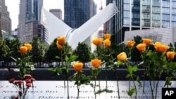 File - Flowers are seen placed into the groves of inscribed names of the victims of the 9/11 terrorist attacks, at the National September 11 Memorial and Museum, Sept. 11, 2020, in New York City.